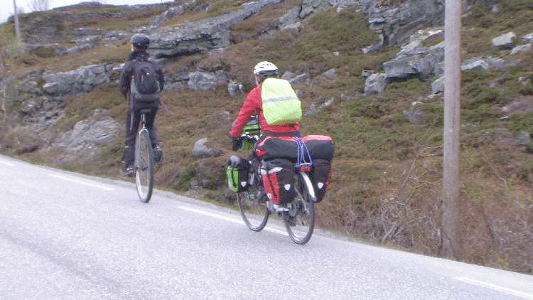 Einradfahrer und Frau mit Gepäck